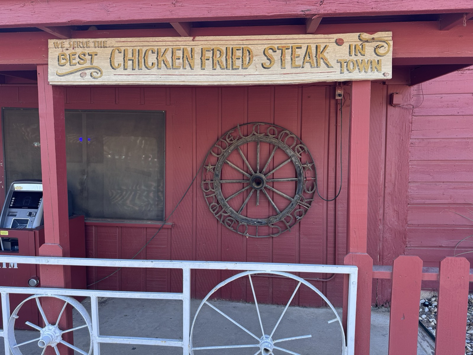 Carved sign on the Broken Spoke's porch: We serve the best chicken fried steak in town