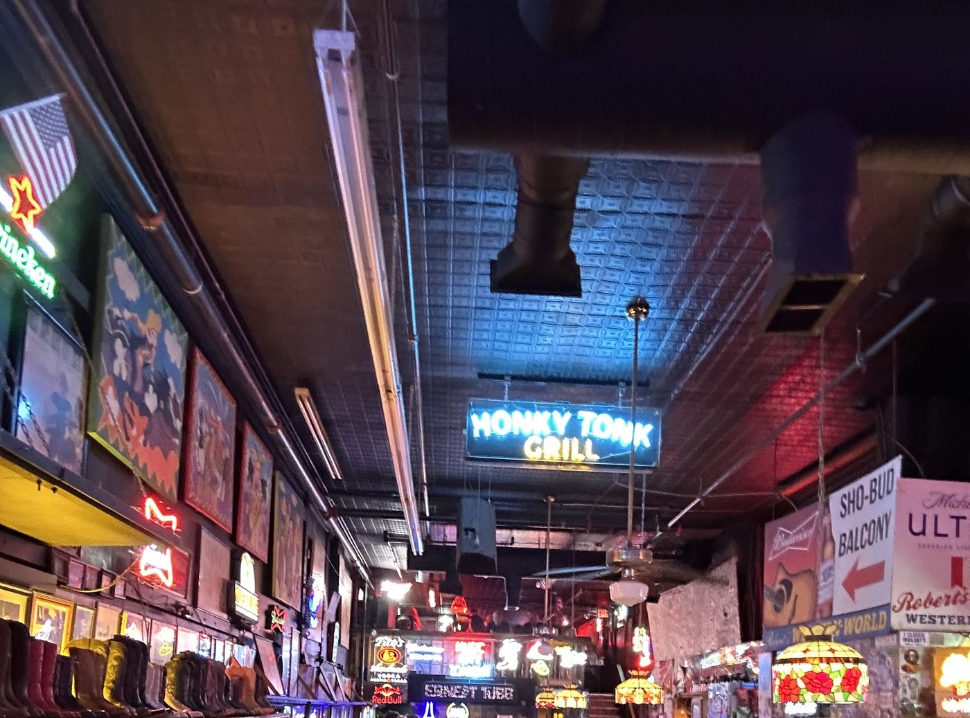 Inside Robert's: the boot shelf on the left wall, the Honky Tonk Grill neon, stained-glass lamps and the Sho-Bud Balcony sign